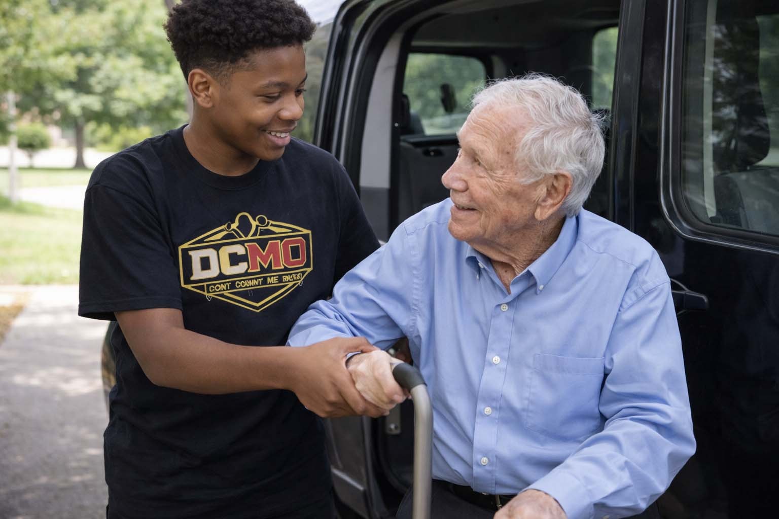 DCMO participant assisting a senior man out of a vehicle
